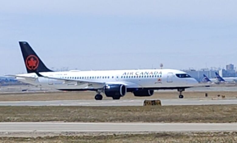 Air Canada passenger jet taxiing on runway with dark tail featuring red maple leaf emblem.