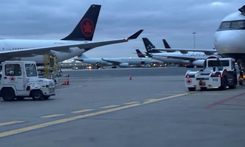 Several passenger jets parked at gates with ground support vehicles on the tarmac, preparing for boarding or service.