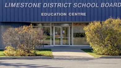 Front entrance of Limestone District School Board Education Centre with a blue exterior and manicured shrubs in the foreground.