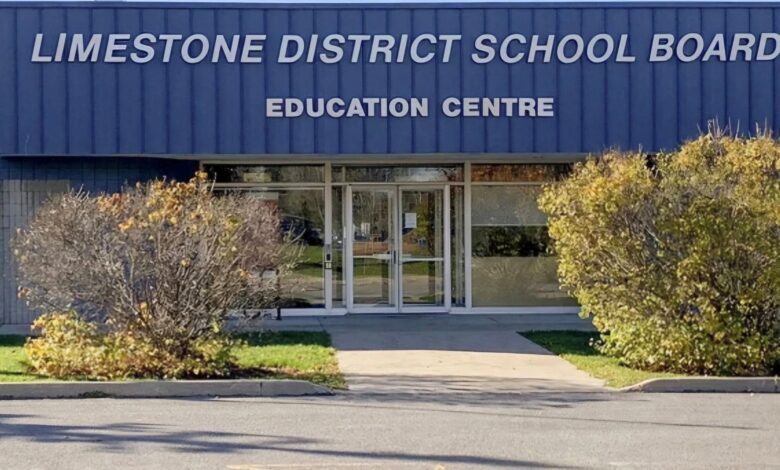 Front entrance of Limestone District School Board Education Centre with a blue exterior and manicured shrubs in the foreground.