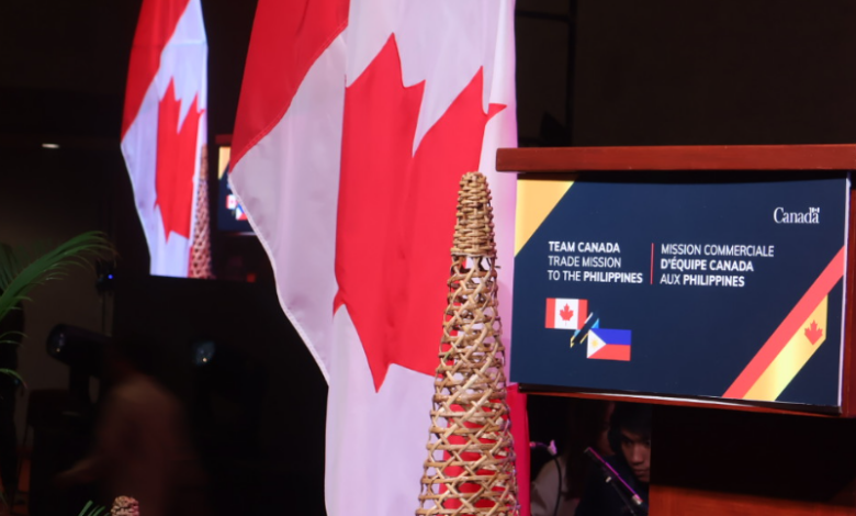 Canadian flag and Philippine flag on a stage with a podium announcing Team Canada trade mission to the Philippines.