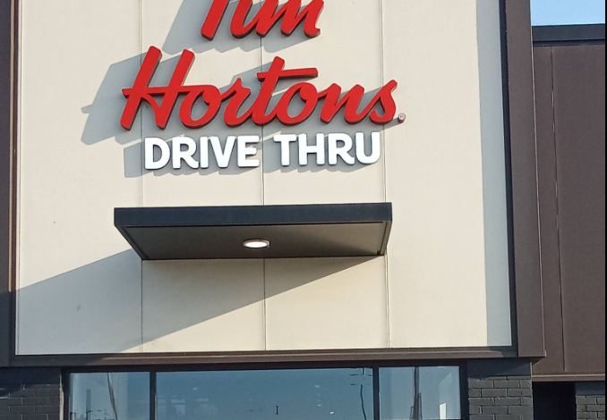 Tim Hortons Drive Thru sign on a storefront exterior with red logo lettering above the entrance