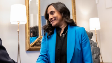 Professional woman in a bright blue blazer smiling during a meeting in an office setting