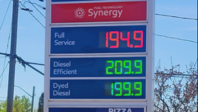 Esso convenience-store sign with Synergy fuel info and prices: full service 194.9, diesel 209.9, dyed diesel 199.9; ATM and pizza/coffee/popcorn notice.