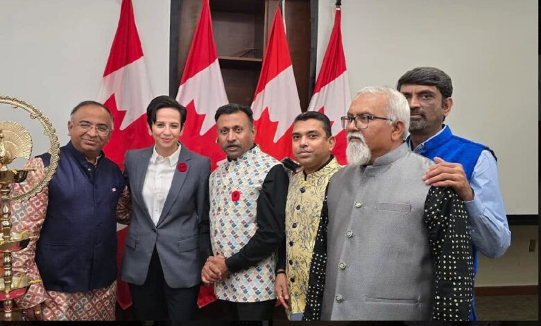 Group of six adults posing for a formal event, with Canadian flags in the background behind them.