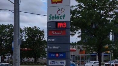 Tall Shell sign with Select branding, displaying fuel price and services (Diesel, Car Wash, ATM) in a gas station lot