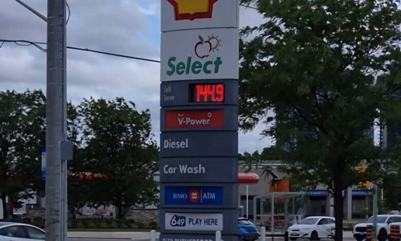 Tall Shell sign with Select branding, displaying fuel price and services (Diesel, Car Wash, ATM) in a gas station lot