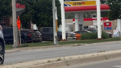 Gas station sign with Boston Pizza and Petro-Canada branding at a street intersection, red maple leaf graphic above the price board