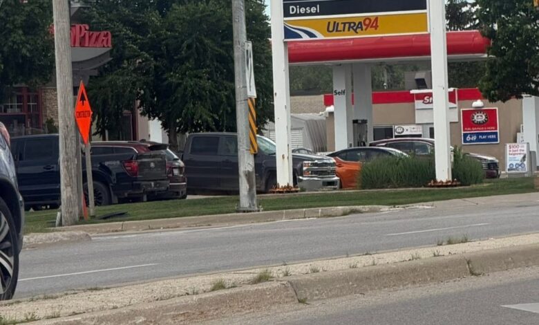 Gas station sign with Boston Pizza and Petro-Canada branding at a street intersection, red maple leaf graphic above the price board