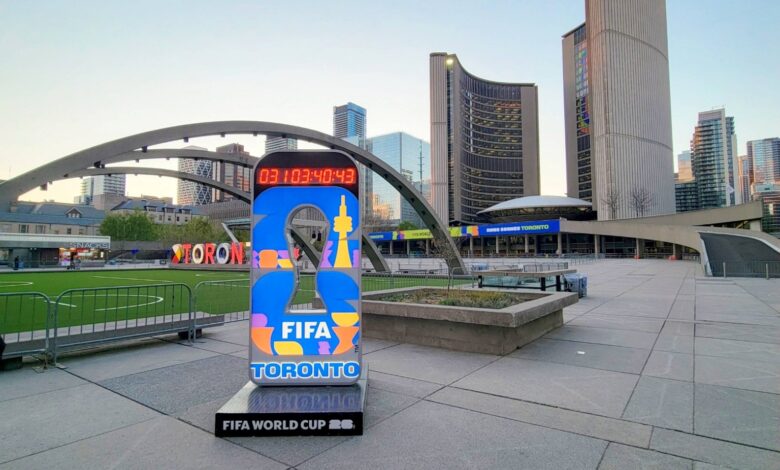 FIFA World Cup Toronto display in an urban square with curved arches and modern high-rise buildings in the background.