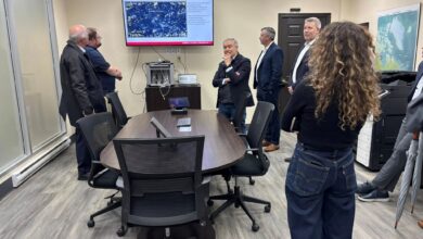 Group of professionals in a conference room watching a fisheries habitat presentation on a wall-mounted screen.